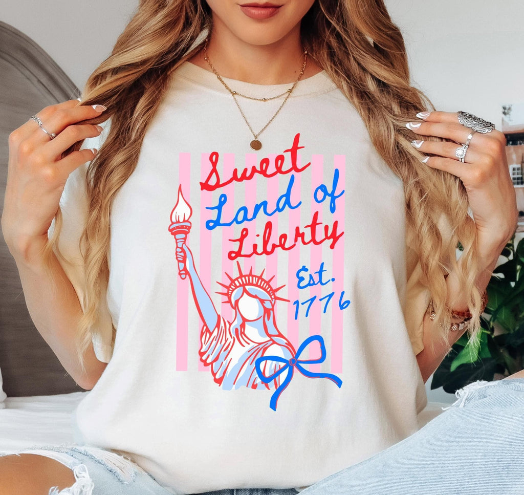 Person wearing a white t-shirt with 'Sweet Land of Liberty' design