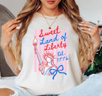 Person wearing a white t-shirt with 'Sweet Land of Liberty' design