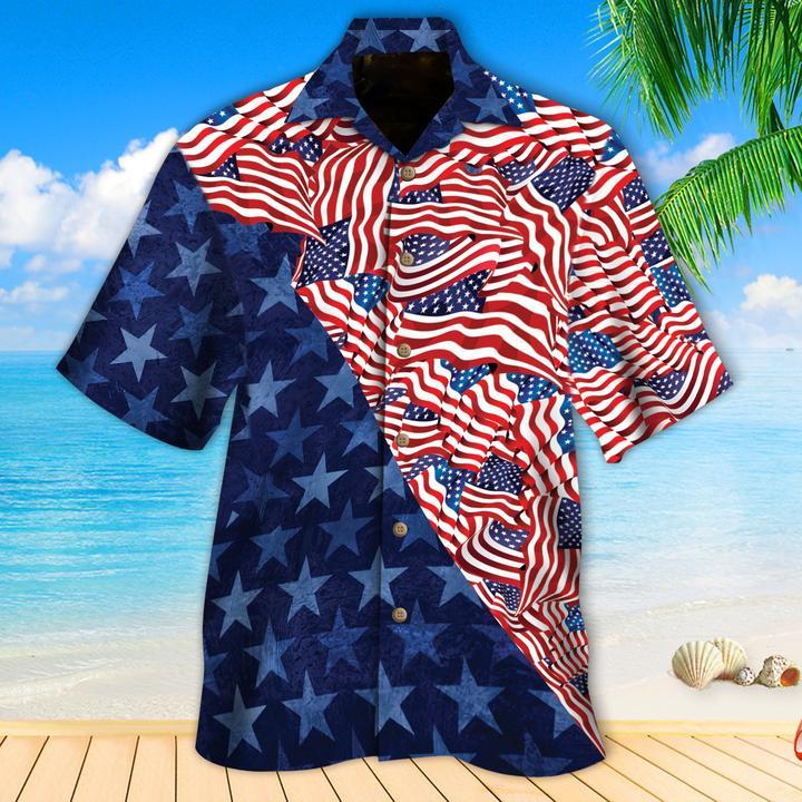 A Hawaiian shirt with a geometric pattern featuring stars and stripes in blue, red, and white colors, displayed against a tropical background with palm trees and a clear blue sky.